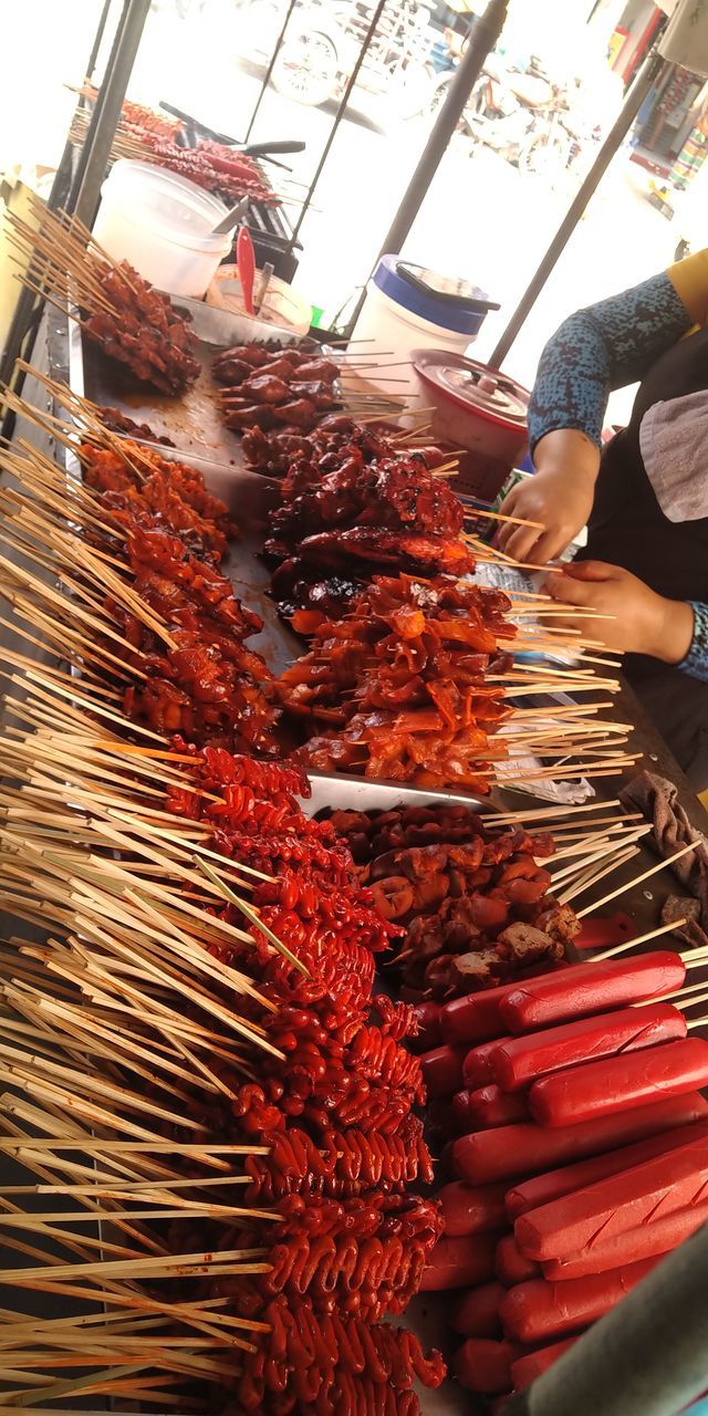 food, food and drink, hanging, business finance and industry, business, freshness, market, retail, abundance, market stall, meat, occupation, large group of objects, day, adult, outdoors, one person, city, seafood, for sale, men, dish, red