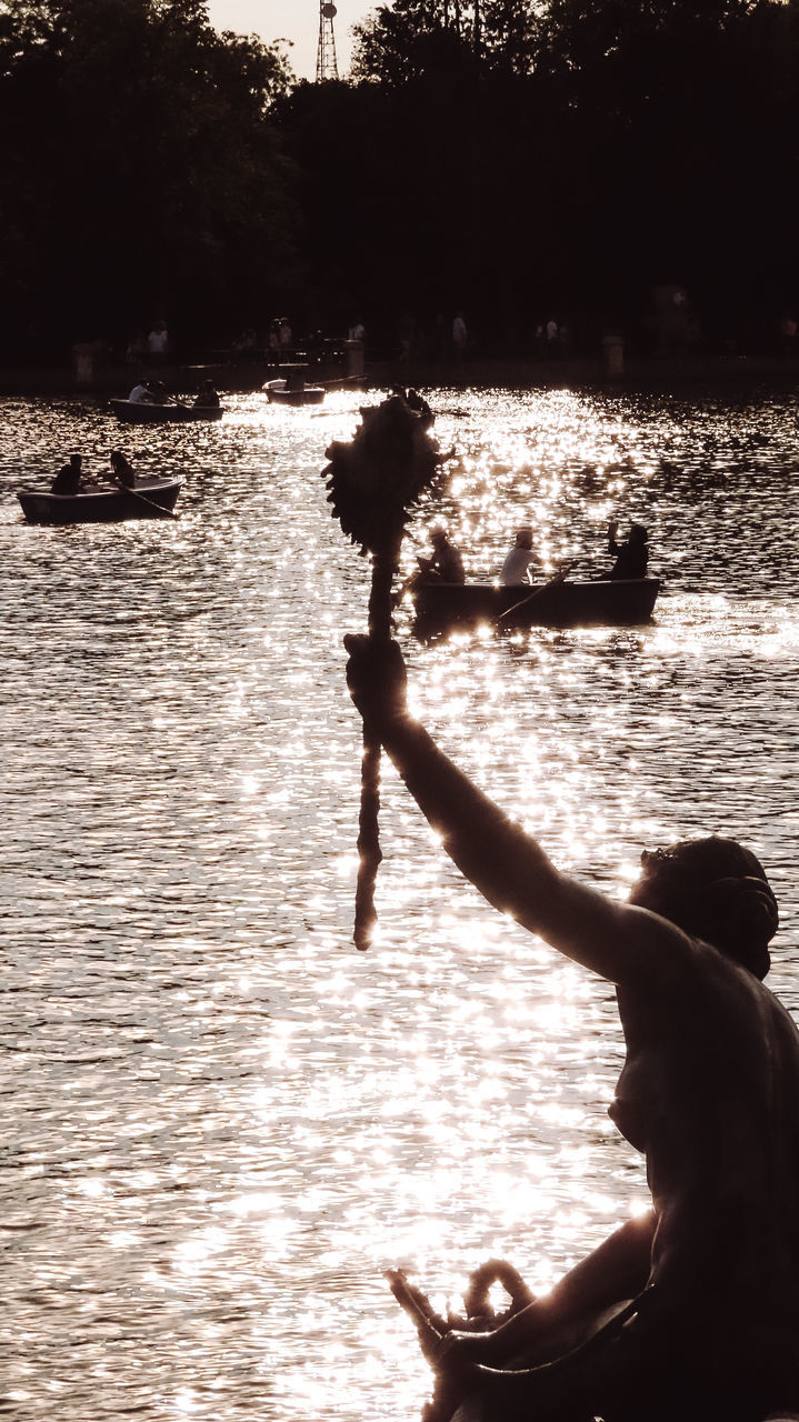 water, nature, silhouette, sunlight, leisure activity, lifestyles, one person, men, adult, sea, outdoors, sunset, beach, day, women, sky, black, child, reflection, full length, side view, person, beauty in nature, land, childhood, sitting, tree, motion, enjoyment