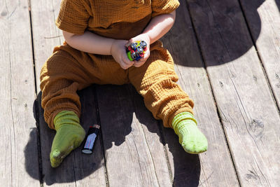 High angle view of boy standing on wooden wall