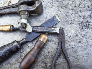 High angle view of various rusty tools on metal table