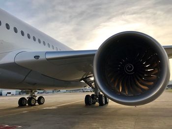 Airplane on airport runway against sky