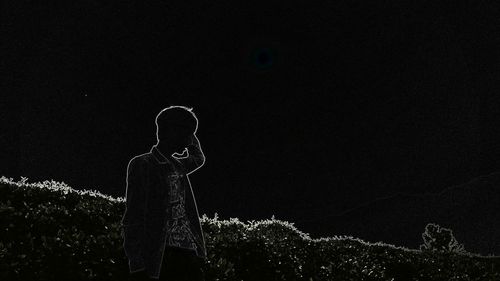 Low angle view of woman standing on field against sky at night