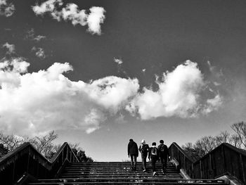 People on staircase against sky