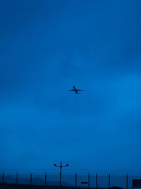 Low angle view of airplane flying against blue sky