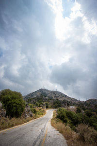 Road leading towards mountain against sky