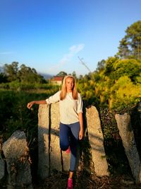 Full length of woman standing by stone on field