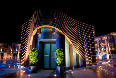 Illuminated building against sky at night