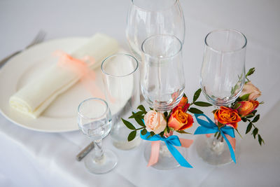 Wedding glasses and plate on the table with decorations and flowers