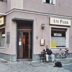 Rear view of man standing on road in front of buildings