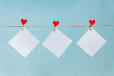 Close-up of clothes hanging on rope against blue wall