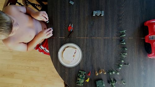 High angle view of woman hand by red wine on table