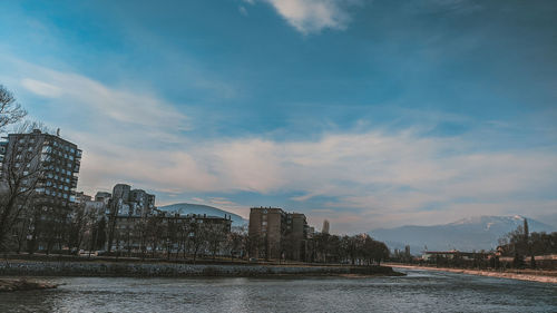 River by buildings against sky in city