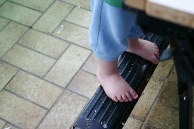 Low section of boy standing on metal in back yard