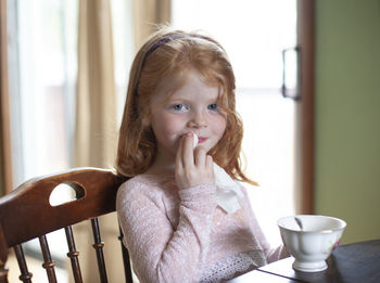 Portrait of cute girl sitting at table