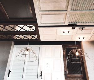 Low angle view of illuminated pendant lights hanging from ceiling at home