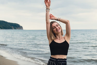 Young woman standing on blurred beachside background. attractive female enjoying walking the sea