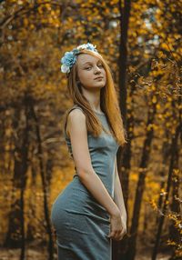 Portrait of woman standing against trees