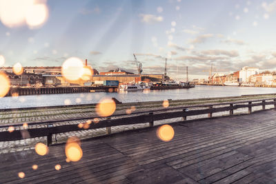 Illuminated bridge over river against sky in city