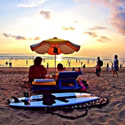 Silhouette of people on beach at sunset