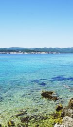 Calm blue sea against clear sky