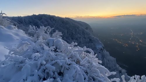 Frozen landscape against sky during sunset