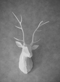 White sculpture of deer on wall