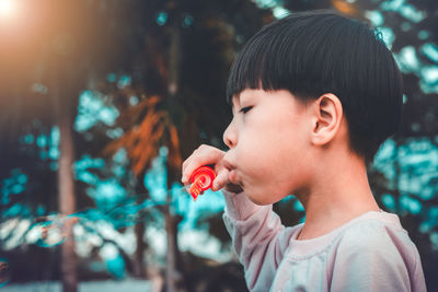 Close-up portrait of boy holding camera