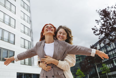 Cheerful young woman hugging mother at hafencity