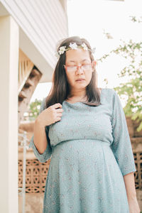 Portrait of woman wearing flower headband standing outdoors