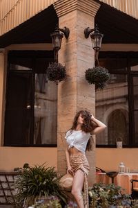 Side view of young woman sitting in front of church