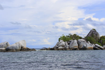 Rock formations in sea against sky