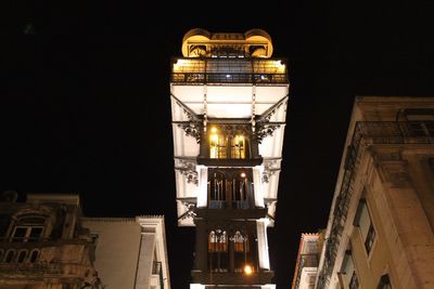 Low angle view of illuminated buildings against sky at night