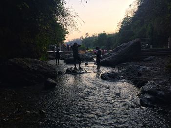 People standing on rock against sky