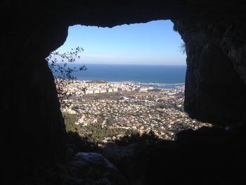 Aerial view of city by sea against sky