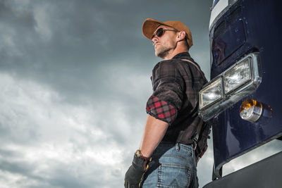 Low angle view of man standing on street against sky