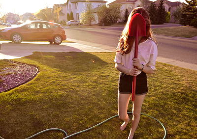 Full length of woman standing by car