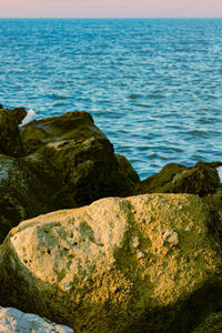 Scenic view of rocks on beach against sky