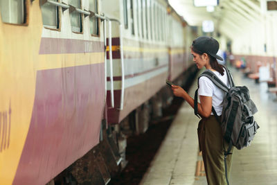 Full length of woman standing on train at railroad station