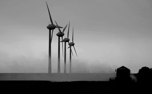 Low angle view of windmill on field against sky