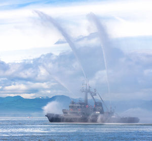 Fire hose boat spraying water on kamchatka on paciic ocean