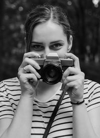 Young woman photographer with analog camera in black and white