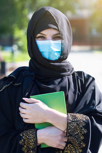 Portrait of young woman holding book