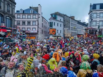 Crowd in city against sky