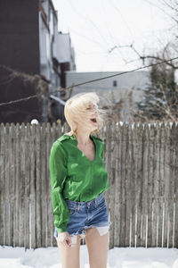 Happy young woman playing in the snow