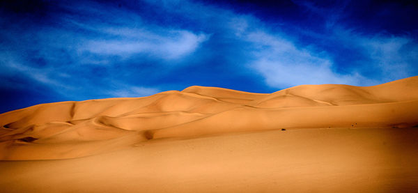 Scenic view of desert against blue sky