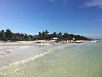 Scenic view of beach against blue sky