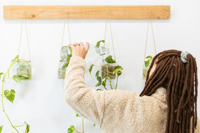 Midsection of woman relaxing on plant at home