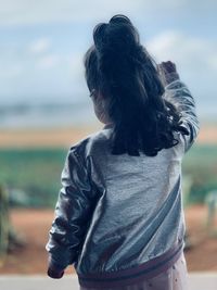 Rear view of woman looking at camera
