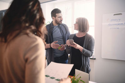 Male engineer discussing with female colleague during meeting in office