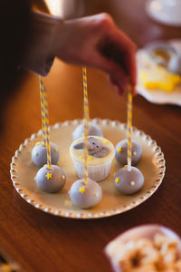 Close-up of hand holding dessert in plate